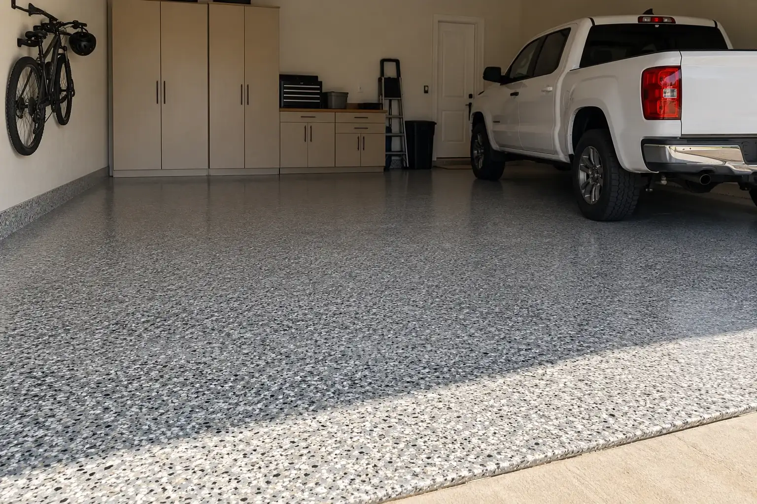 Home garage with a gray flake epoxy floor and a white pickup